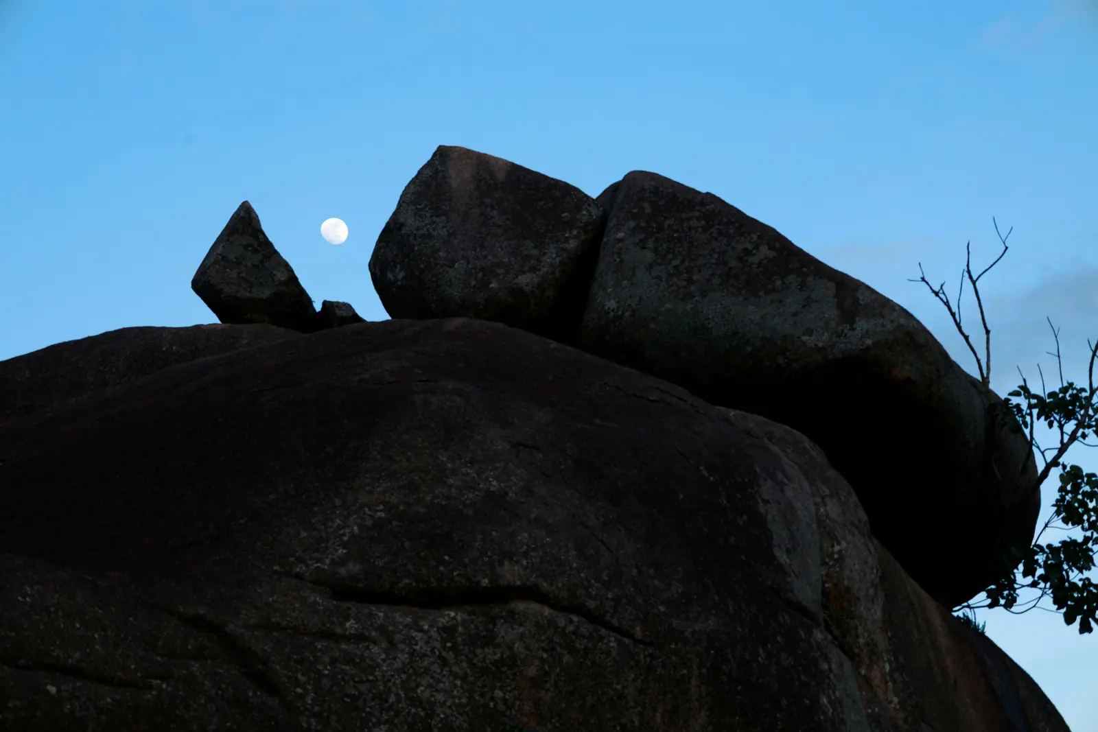 The moon rising behind Abuja's granite rocks at dusk